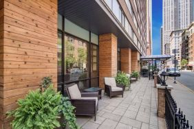 The hotel’s terrace by the entrance features armchairs, coffee tables, and potted plants.