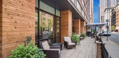 The hotel’s terrace by the entrance features armchairs, coffee tables, and potted plants.