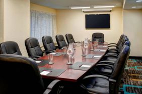 Meeting room in Sonesta ES Suites Chicago Downtown Magnificent Mile - Medical, with long wooden table, black leather chairs, and a TV.