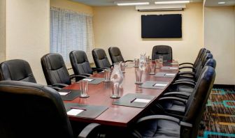 Meeting room in Sonesta ES Suites Chicago Downtown Magnificent Mile - Medical, with long wooden table, black leather chairs, and a TV.