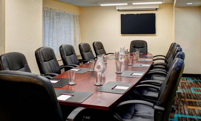 Meeting room in Sonesta ES Suites Chicago Downtown Magnificent Mile - Medical, with long wooden table, black leather chairs, and a TV.