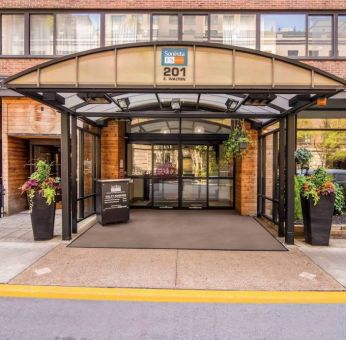 Sonesta ES Suites Chicago Downtown Magnificent Mile - Medical’s exterior has a covered entranceway and numerous potted plants.