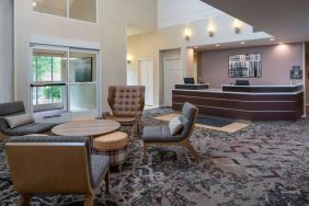 The lounge in Sonesta ES Suites Nashville Brentwood’s lobby features a quartet of comfy chairs, a snazzy carpet, and a coffee table. 