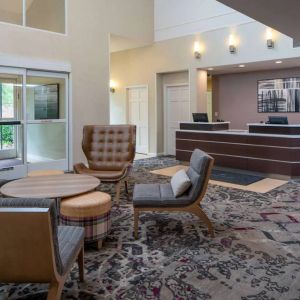 The lounge in Sonesta ES Suites Nashville Brentwood’s lobby features a quartet of comfy chairs, a snazzy carpet, and a coffee table. 