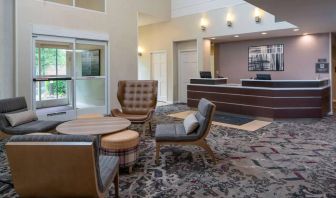 The lounge in Sonesta ES Suites Nashville Brentwood’s lobby features a quartet of comfy chairs, a snazzy carpet, and a coffee table. 