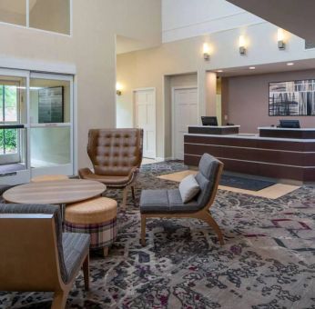 The lounge in Sonesta ES Suites Nashville Brentwood’s lobby features a quartet of comfy chairs, a snazzy carpet, and a coffee table. 