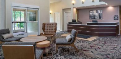 The lounge in Sonesta ES Suites Nashville Brentwood’s lobby features a quartet of comfy chairs, a snazzy carpet, and a coffee table. 