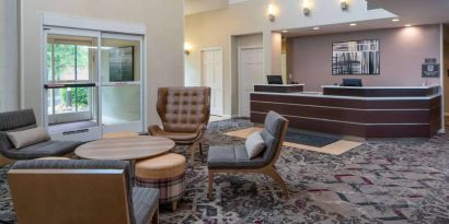 The lounge in Sonesta ES Suites Nashville Brentwood’s lobby features a quartet of comfy chairs, a snazzy carpet, and a coffee table. 