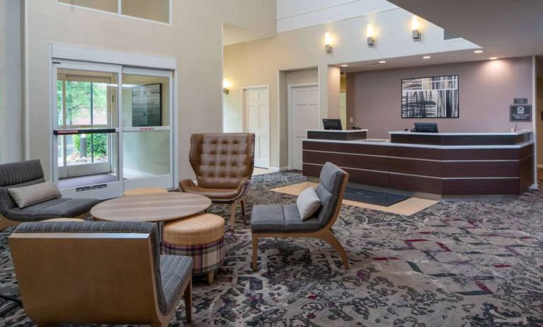 The lounge in Sonesta ES Suites Nashville Brentwood’s lobby features a quartet of comfy chairs, a snazzy carpet, and a coffee table. 