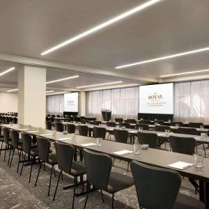 Large meeting room in Royal Sonesta Minneapolis Downtown, with lectern, large screens, and space for seating for several dozen attendees.