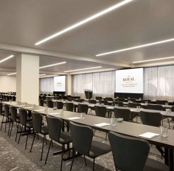 Large meeting room in Royal Sonesta Minneapolis Downtown, with lectern, large screens, and space for seating for several dozen attendees.