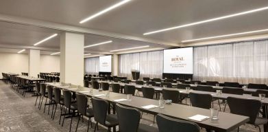 Large meeting room in Royal Sonesta Minneapolis Downtown, with lectern, large screens, and space for seating for several dozen attendees.