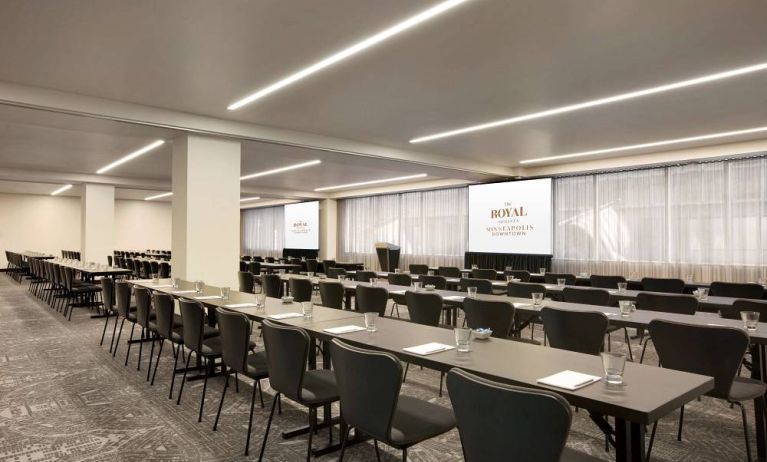 Large meeting room in Royal Sonesta Minneapolis Downtown, with lectern, large screens, and space for seating for several dozen attendees.