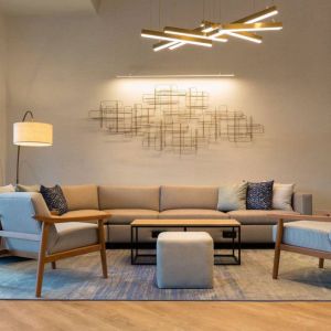 Sonesta Silicon Valley’s lobby is furnished with a comfortable sitting area, with long sofa, chairs, and multiple coffee tables.