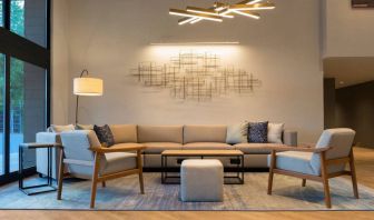 Sonesta Silicon Valley’s lobby is furnished with a comfortable sitting area, with long sofa, chairs, and multiple coffee tables.