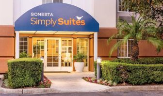 Sonesta Simply Suites Irvine East Foothill’s exterior features a covered entranceway, clear signage, and pleasant greenery.