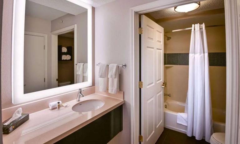 Sonesta ES Suites San Jose Airport guest room bathroom, featuring sink, mirror, bath, shower, and lavatory.