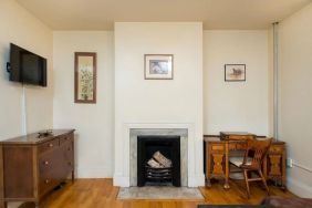 Day use room with TV, workspace, and chimney at The Farrington Inn.