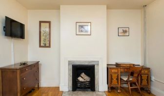 Day use room with TV, workspace, and chimney at The Farrington Inn.