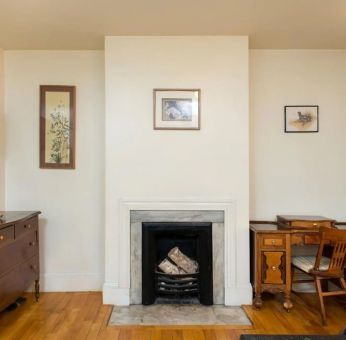 Day use room with TV, workspace, and chimney at The Farrington Inn.