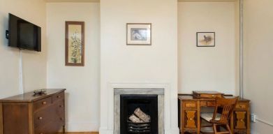 Day use room with TV, workspace, and chimney at The Farrington Inn.