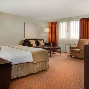 Sonesta Miami Airport double bed guest room, furnished with armchair, sofa, and window.