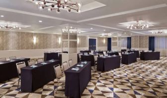 Large meeting room in Royal Sonesta Washington DC Dupont Circle, with tables of three seats each arranged in a classroom style.