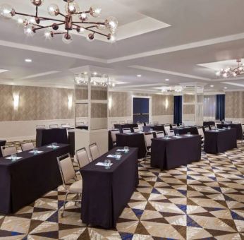 Large meeting room in Royal Sonesta Washington DC Dupont Circle, with tables of three seats each arranged in a classroom style.