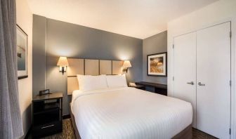 Sonesta Simply Suites Arlington double bed guest room, furnished with bedside cabinets and art on the walls.