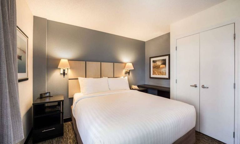 Sonesta Simply Suites Arlington double bed guest room, furnished with bedside cabinets and art on the walls.