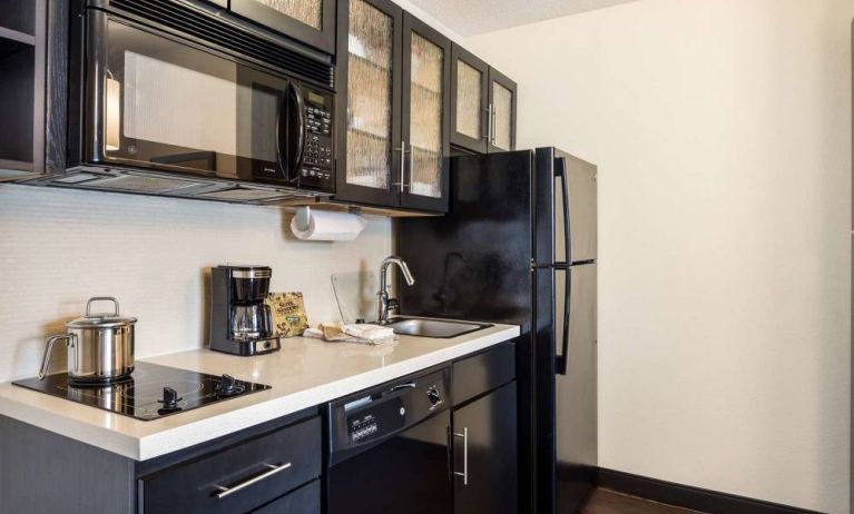 Sonesta Simply Suites Baltimore BWI Airport day room kitchen, fully equipped with fridge freezer, and hob, oven, and microwave.