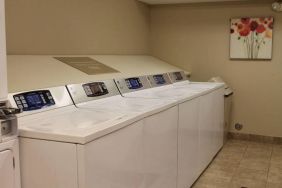 The hotel’s laundry room has numerous machines for guests to use, and art on the wall.