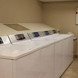 The hotel’s laundry room has numerous machines for guests to use, and art on the wall.