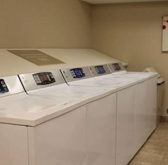 The hotel’s laundry room has numerous machines for guests to use, and art on the wall.