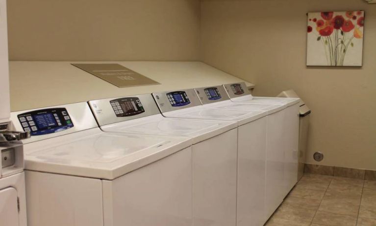 The hotel’s laundry room has numerous machines for guests to use, and art on the wall.