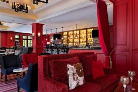 The Stephen F Austin Royal Sonesta Hotel’s bar has vibrant red decor, and a mix of comfortable table seating and traditional bar stools.