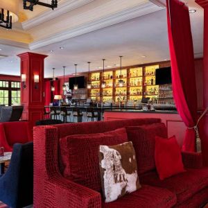 The Stephen F Austin Royal Sonesta Hotel’s bar has vibrant red decor, and a mix of comfortable table seating and traditional bar stools.