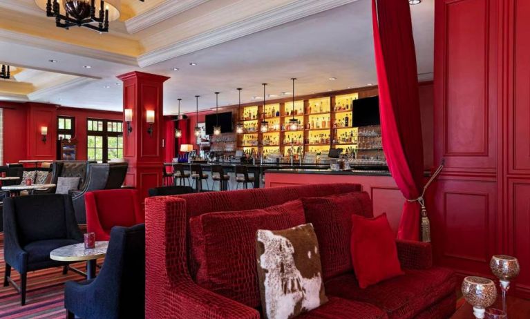 The Stephen F Austin Royal Sonesta Hotel’s bar has vibrant red decor, and a mix of comfortable table seating and traditional bar stools.