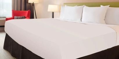 King bed with natural light at Country Inn & Suites By Radisson, Chicago O'Hare South.