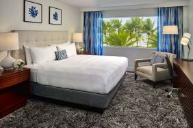 Double bed guest room in Sonesta Fort Lauderdale Beach, furnished with armchair plus workspace desk and chair.