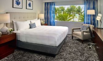 Double bed guest room in Sonesta Fort Lauderdale Beach, furnished with armchair plus workspace desk and chair.