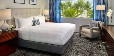 Double bed guest room in Sonesta Fort Lauderdale Beach, furnished with armchair plus workspace desk and chair.