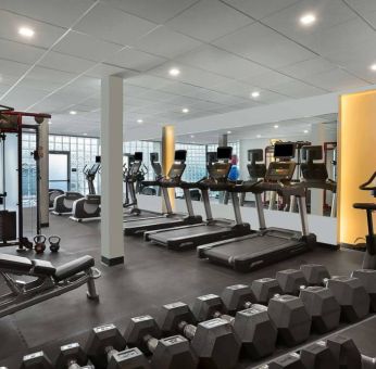 The hotel fitness center has rows of free weights, both dumbbells and kettlebells, and an assortment of exercise machines.