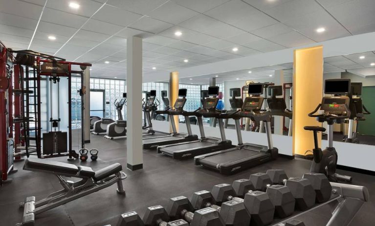 The hotel fitness center has rows of free weights, both dumbbells and kettlebells, and an assortment of exercise machines.