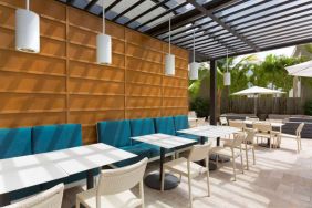 The hotel patio features tables and chairs where guests can relax and socialize in the open air.