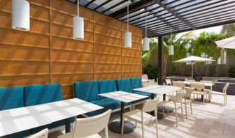 The hotel patio features tables and chairs where guests can relax and socialize in the open air.