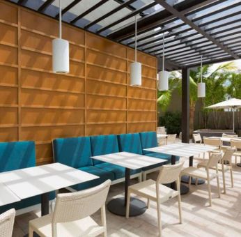 The hotel patio features tables and chairs where guests can relax and socialize in the open air.