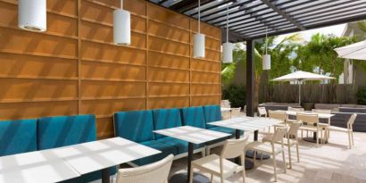 The hotel patio features tables and chairs where guests can relax and socialize in the open air.