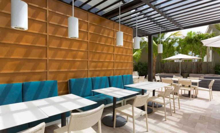 The hotel patio features tables and chairs where guests can relax and socialize in the open air.