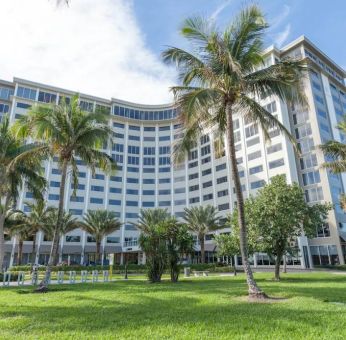 Sonesta Fort Lauderdale Beach’s exterior has extensive greenery, including numerous palm trees.